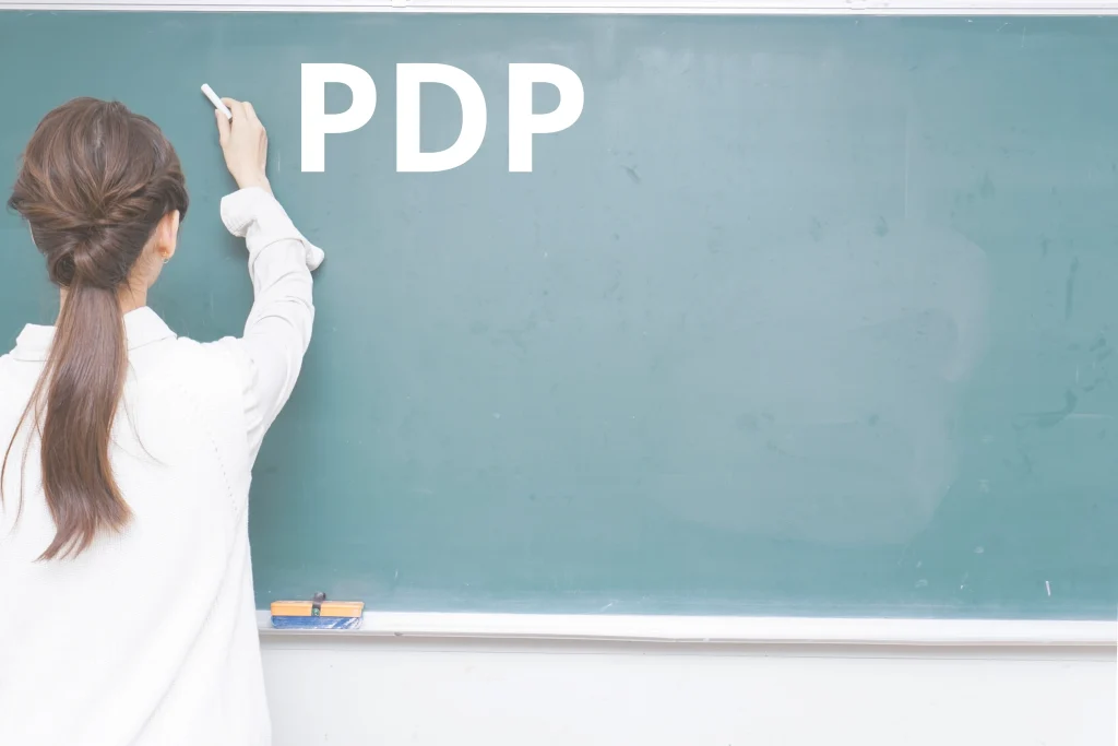 Insegnante scrive alla lavagna durante una lezione con Piano Didattico Personalizzato (PDP)